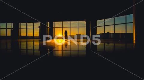 The man stand in a skyscraper business center windows on a background of su.. Stock Photos