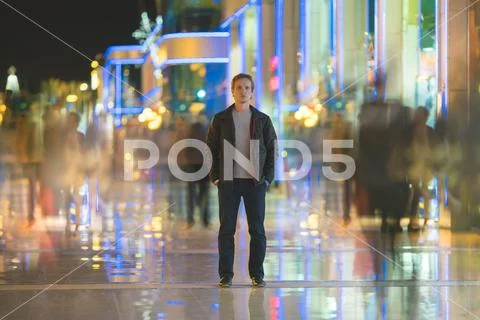 The man stand in the smash ghost crowd stream. Evening night time Stock Photos
