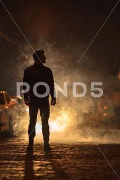 The man stand on the smoky street. Evening night time. Telephoto lens shot Stock Photos