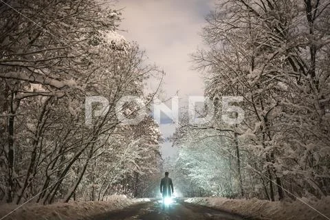 The man stand on the snowy road on the bright light background Stock Photos