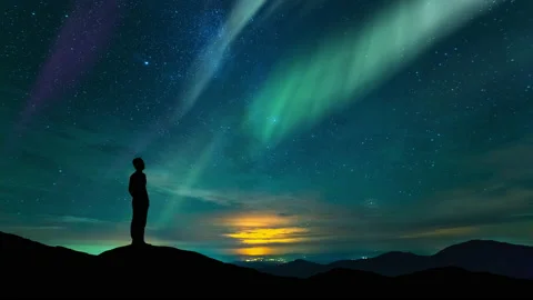 The man stand on a starry sky background with a polar light. time lapse Stock Footage 160125128