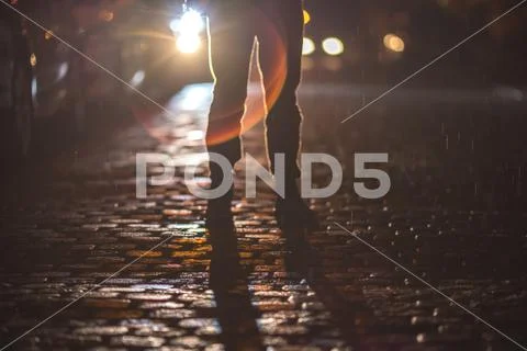 The man stand on the stone road. Evening night time. Telephoto lens shot Stock Photos