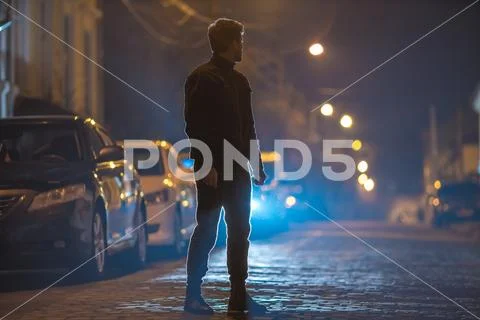 The man stand on the stone road. Evening night time. Telephoto lens shot Stock Photos
