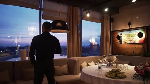 The man stand at the window on a background of the city river Stock Footage 85261270