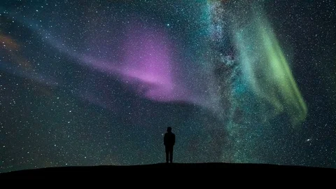 The man standing against a meteor shower with a northern light. time lapse Stock Footage