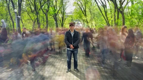 Man standing alone in blurred crowd, on background green trees. Time Lapse Vidéo 80091102