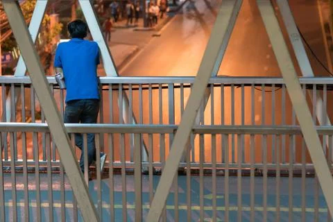 Man standing alone on the bridge. Stock Photos