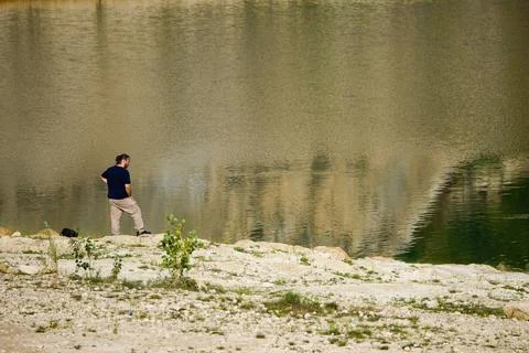 Man Standing Alone by Lake, Reflection and Solitude Concept Stock Photos