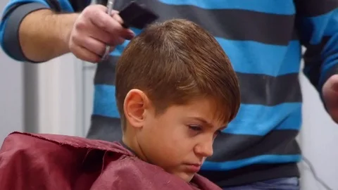 The man is standing and combs small boy's hair. Stock Footage 71934583
