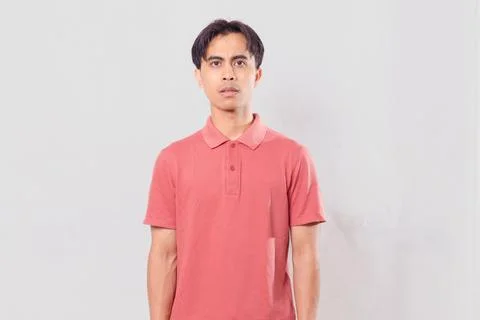 Man standing and looking at the camera with a neutral facial expression, is.. Stock Photos