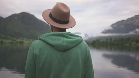 Man standing and looking at view of mountain lake in fog Stock Footage 132060633