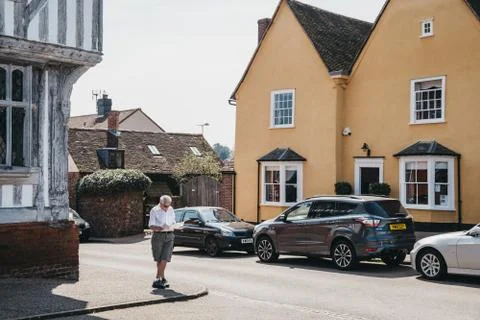 Man standing and reading a map in front of colourful cottages in Lavenham, UK Stock Photos