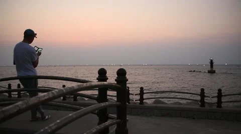 Man standing and using smart phone on beach after sunset Stock Footage 54317580