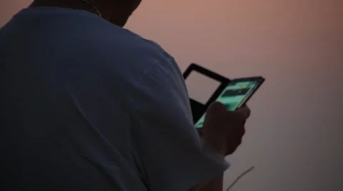 Man standing and using smart phone on beach after sunset Video stock 54317657
