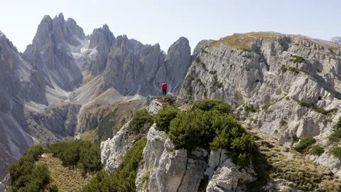 Man standing and walking on mountain ridge epic drone view dolomites Stock Footage 143370442