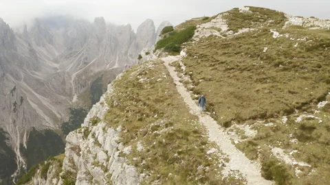 Man standing and walking on mountain ridge epic drone view dolomites Stock Footage 143371354