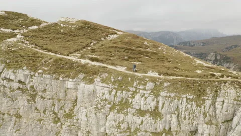 Man standing and walking on mountain ridge epic drone view dolomites Stock Footage 143371599