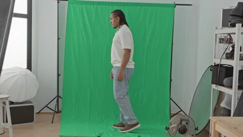 Man standing with arms crossed in front of a green backdrop in a studio, si.. Stock Footage 339165747