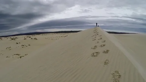 Man standing atop a sand dune Stock Footage 70939758