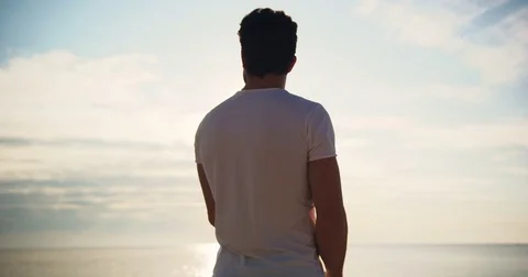 A man standing by back on the beach resting up the sun thinks enjoying the Stock Footage 81683074