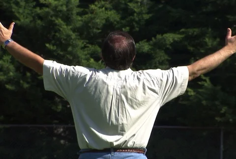 Man standing with back to camera, arms raised Stock Footage 86919838