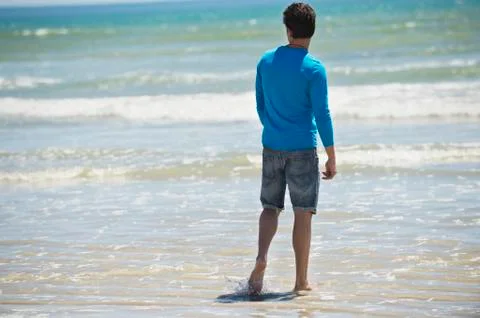 Man standing on the beach and looking at the sea Stock Photos