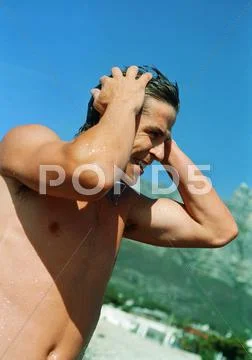 Man Standing On Beach With Hands On Head, Close-Up