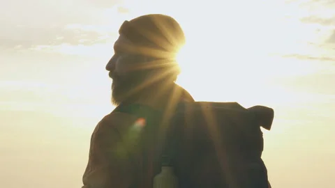 Man standing on the beach, looking around and enjoying sunset time. Video stock 106818368