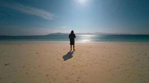 Man Standing on Beach Looking at Ocean Stockfoto's