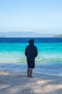 Man Standing on Beach Looking at Ocean Фото