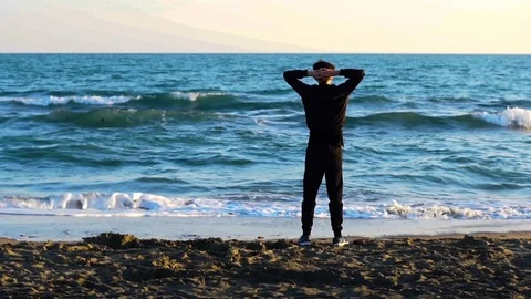 Man standing on the beach on the sea, beautiful seascape. Slow motion. Stock Footage 80309604