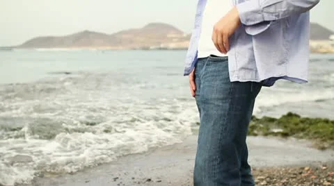 Man standing on the beach, slow motion, steadicam shot HD Stock Footage 10860130