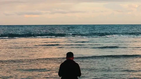Man Standing on the Beach at Sunset Stock Footage 277675805
