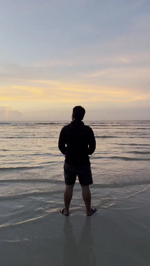 Man Standing on Beach at Sunset Stock Footage 338051494
