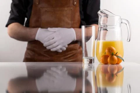 Man standing behind the composition of orange juice jar and few tangerines near Stock Photos