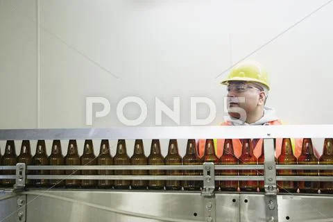 Man standing behind conveyor belt Stock Photos