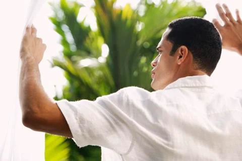 Man standing between open white curtains Stock Photos