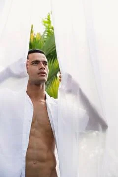 Man standing between open white curtains Stock Photos