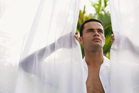 Man standing between open white curtains Stock Photos