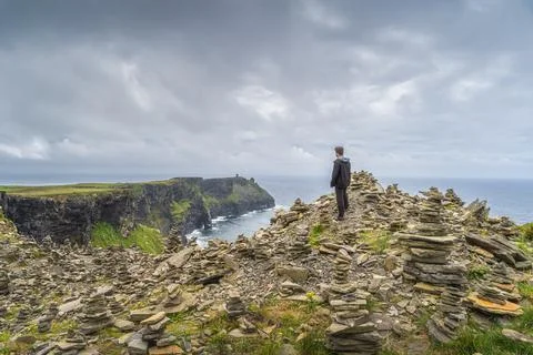 Man standing between stone stackings and admiring view on in iconic Cliffs of Stock Photos