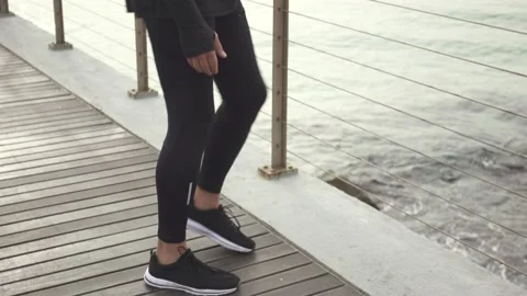Man standing on the bridge doing exercises for legs before jogging Stock Footage 132041801