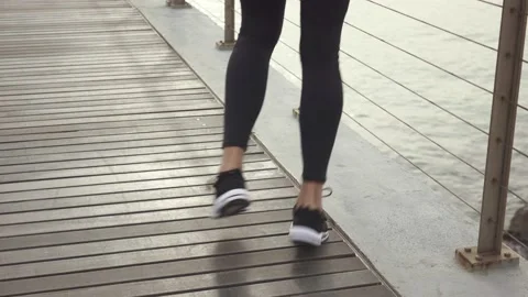 Man standing on the bridge doing exercises for legs before jogging. Man jumping Stock Footage 132041915