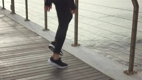Man standing on the bridge doing exercises for legs before jogging Stock Footage 132041951