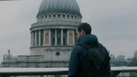 Man standing on bridge overlooking St Paul’s Cathedral Stock Footage 130974747