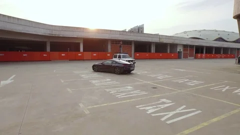 Man standing on a car and photographing in a parking lot Video stock 71567775
