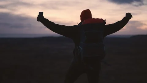 Man Standing on Cliff Overlooking Vast Icelandic Landscape Vídeo Stock 307421894