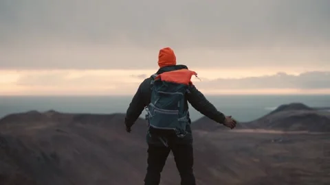 Man Standing on Cliff Overlooking Vast Icelandic Landscape 스톡 동영상 307422083