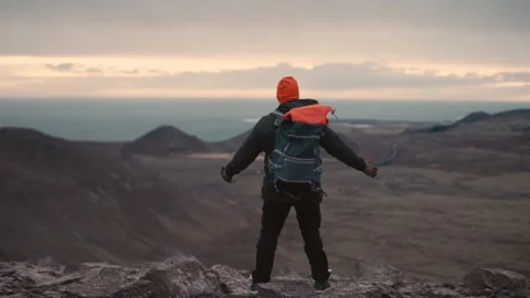 Man Standing on Cliff Overlooking Vast Icelandic Landscape Video stock 307422104