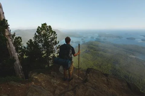 Man standing on the cliff with view on ocean and islands Stock Photos