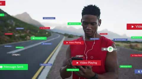 Man standing on coast road tapping phone UI popping urging play button while Stock Footage 334322228